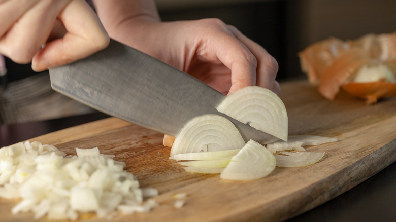 person chopping white onions