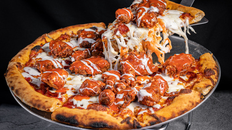 lifting slice of buffalo chicken pizza