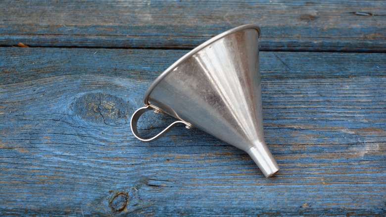 metal funnel on wooden table