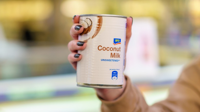 canned coconut milk in hand