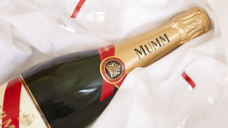 bottle of Mumm Champagne and glasses lying on a white cloth