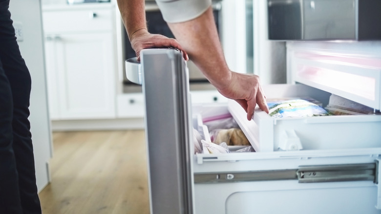 Person opening freezer door