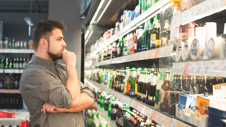 Man looking at bottles of beer on a shelf