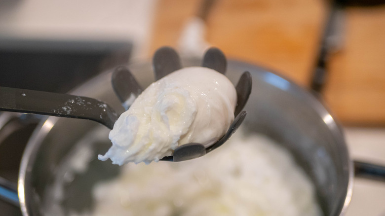 Poached egg in slotted spoon