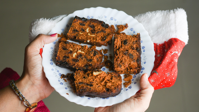 Person holding plate of fruitcake