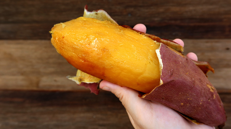 cooked sweet potato being peeled