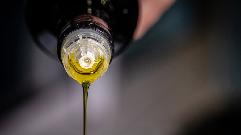 Olive oil being poured from a bottle.