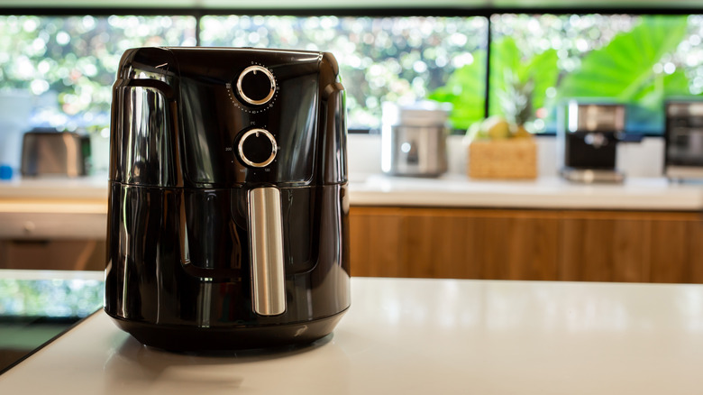 Air fryer on white kitchen countertop.