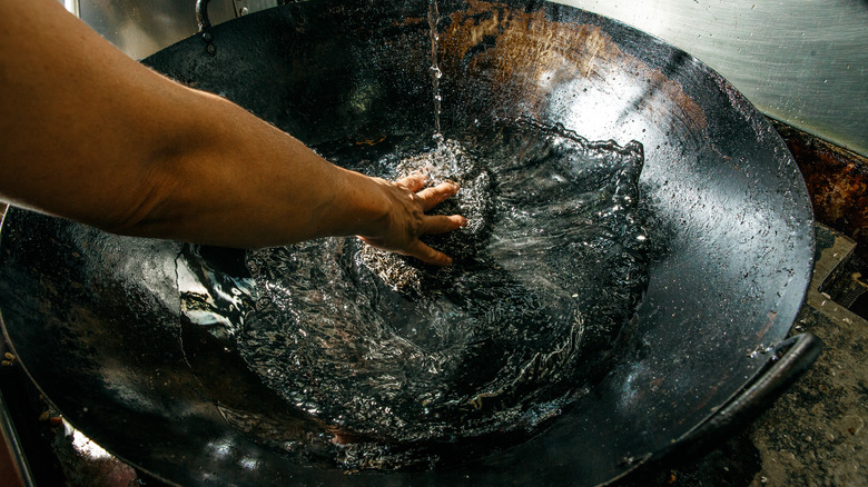 Person cleaning a wok