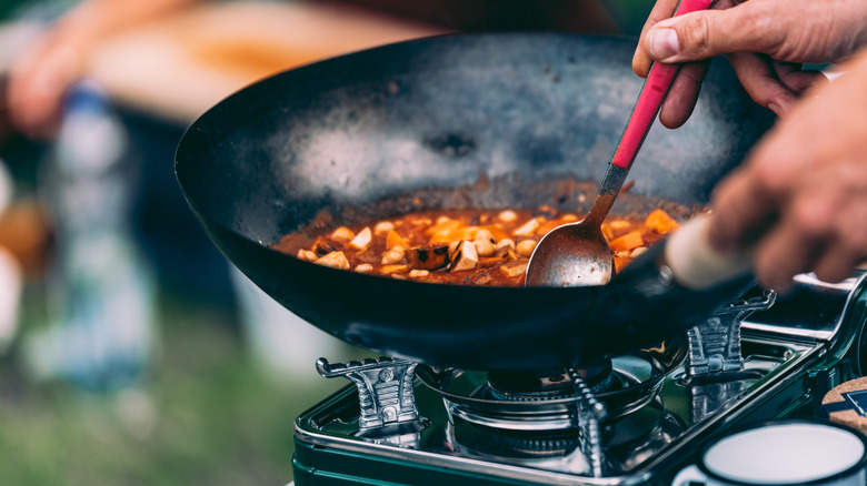 Person making curry in wok