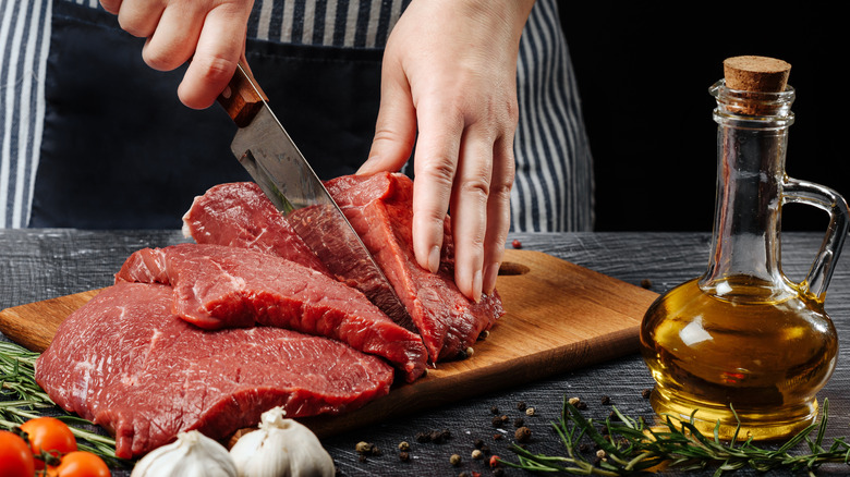 Hands cutting steak