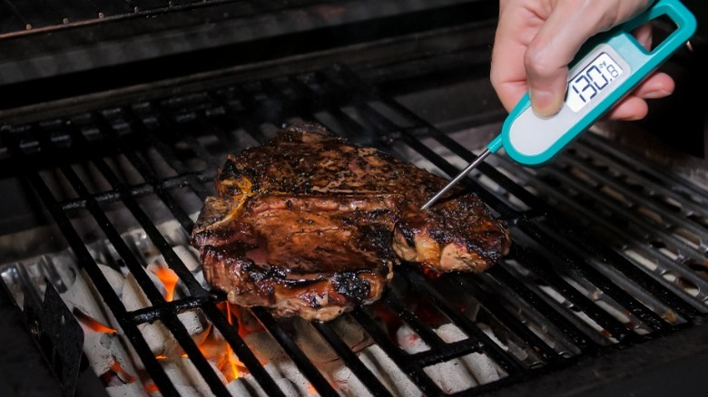 Checking steak with thermometer