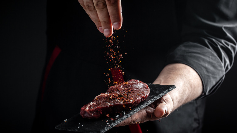 Hand seasoning steak