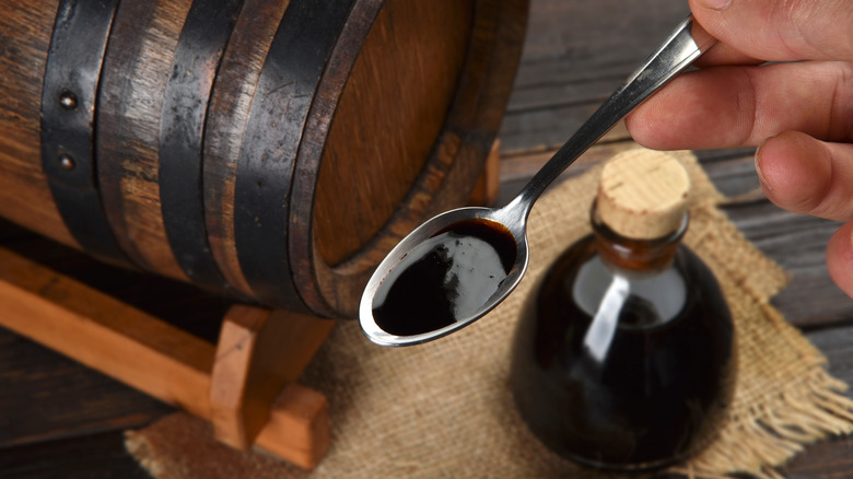 Spoonful of balsamic vinegar with bottle and barrel