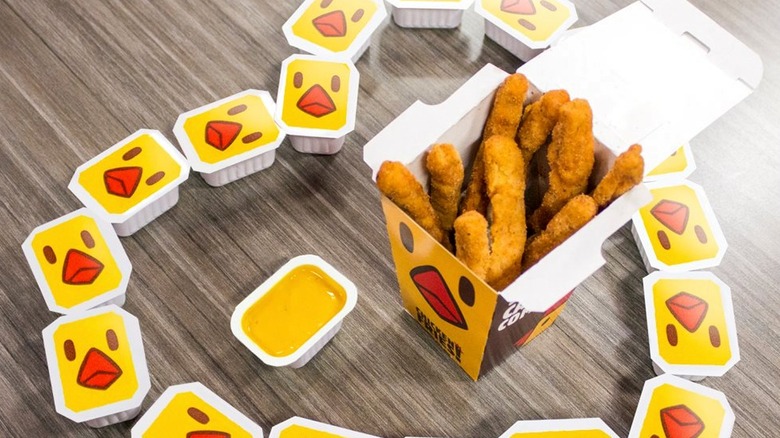 Burger King Chicken Fries, surrounded by cartons of Chicken Fries Sauce