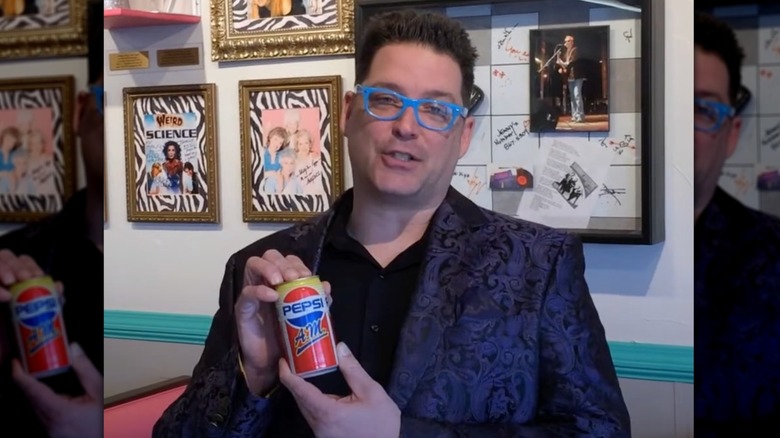 Man holding can of Pepsi A.M., with retro memorabilia behind him