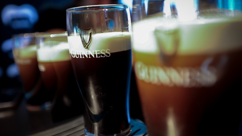 Partially poured glasses of Guinness