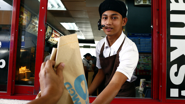 Worker handing out McDonald's bag