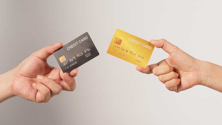 Two hands holding credit cards