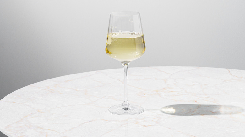 Glass of white wine on white round table