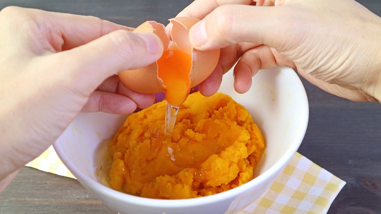 Cracking egg into canned pumpkin