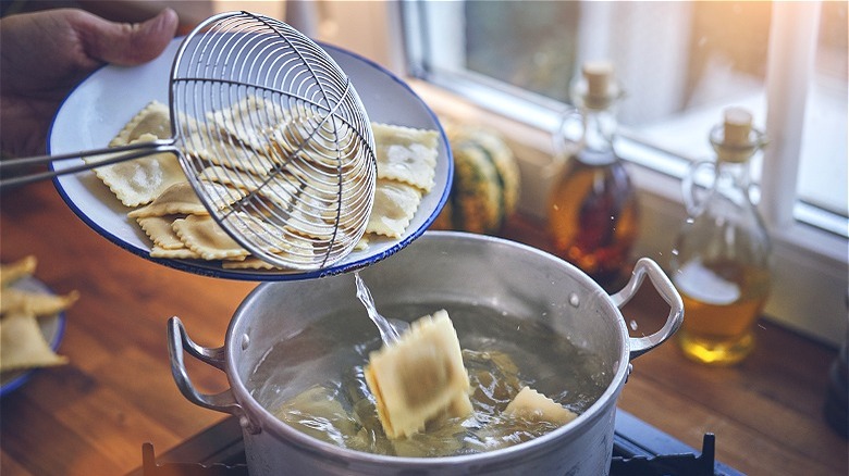 ravioli being tossed into pot