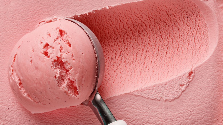 person scooping strawberry ice cream