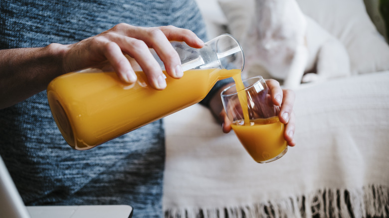 person pouring fruit juice