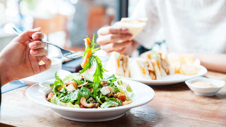 people eating salad and sandwich