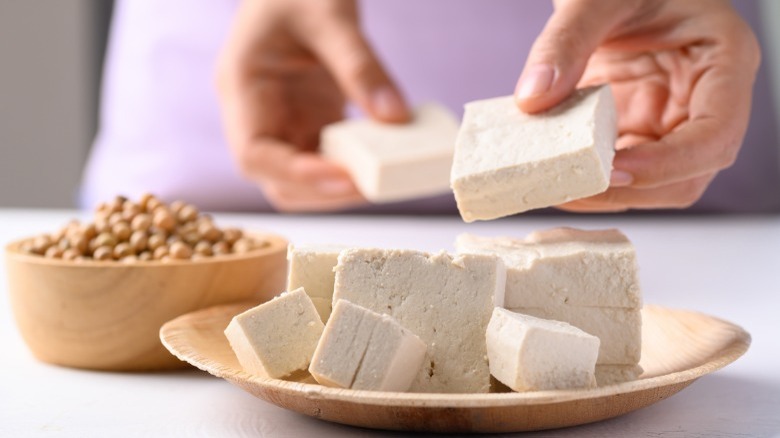 Chef handling tofu on plate