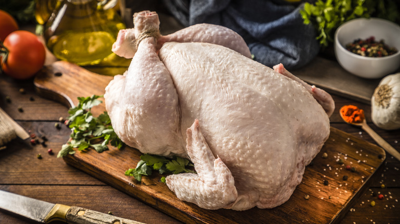 Raw chicken on wooden board