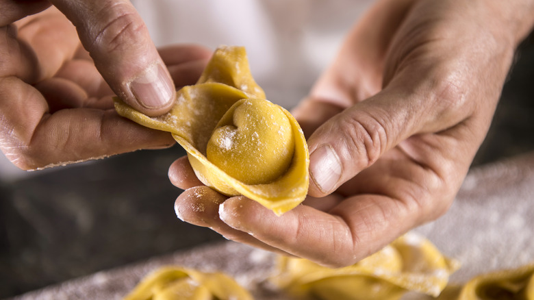 person making tortellini