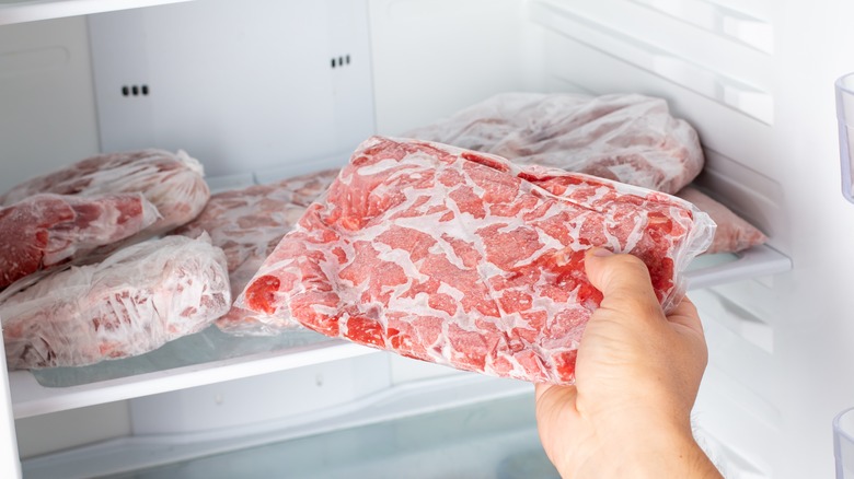 removing package of raw meat from freezer