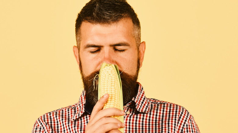 man smelling corn