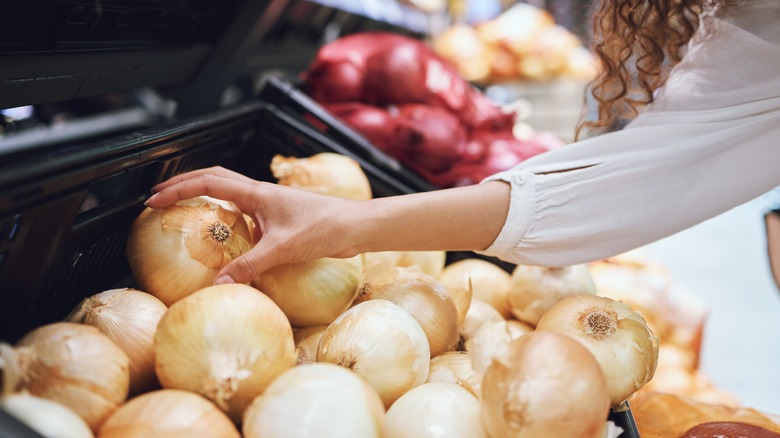 picking up onion in supermarket