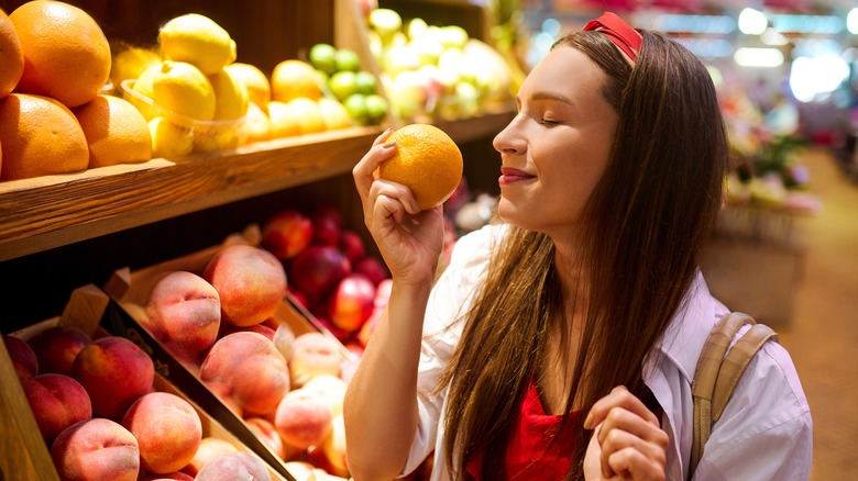 young woman smelling orange