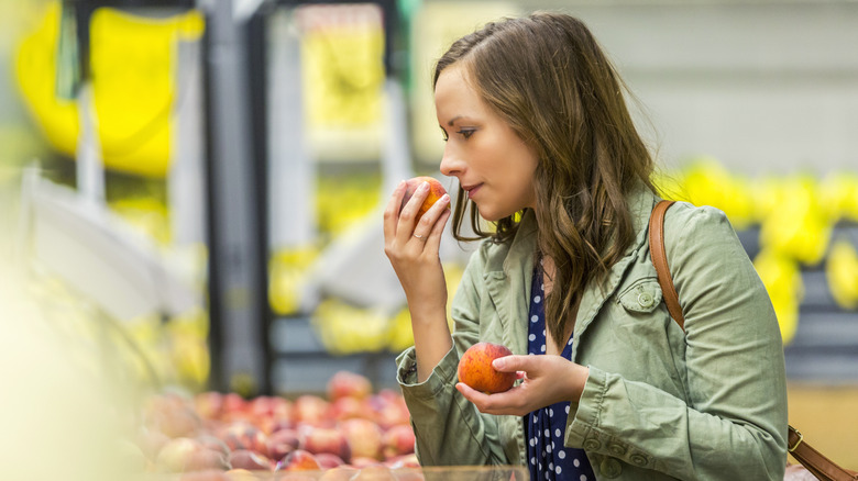 woman smelling peach