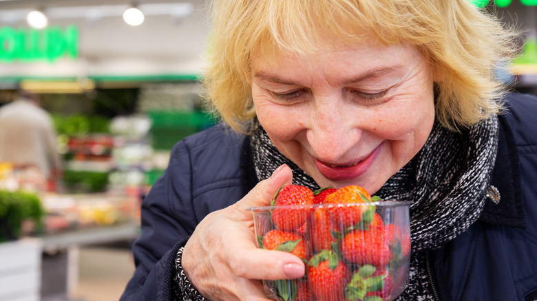 woman smelling strawberries