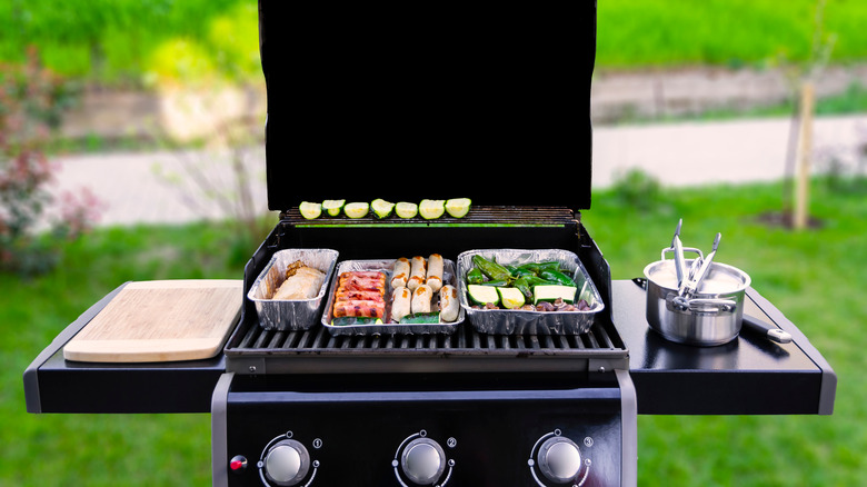 gas grill with food and utensils