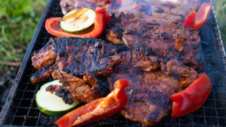 meat and peppers on a grill