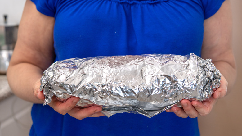 woman holding meat in foil