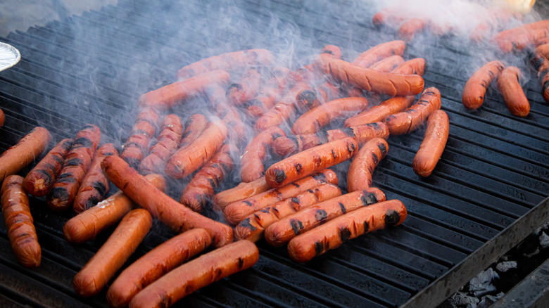 smoking hot dogs on grill