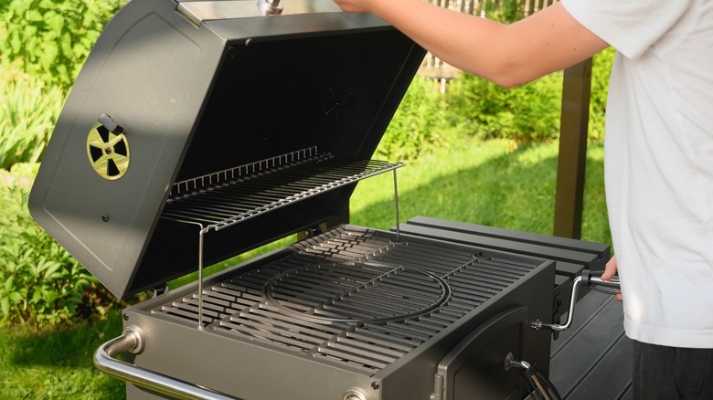 man opening portable charcoal grill