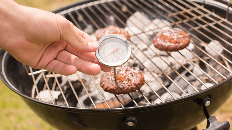 checking burgers with meat thermometer
