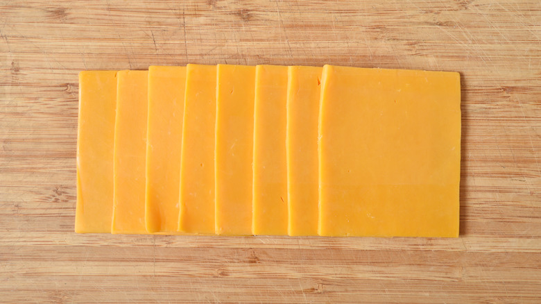 cheddar cheese slices on chopping board