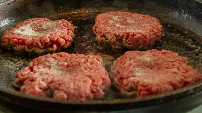 burgers with dimples frying