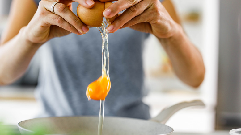 woman cracking egg into bowl