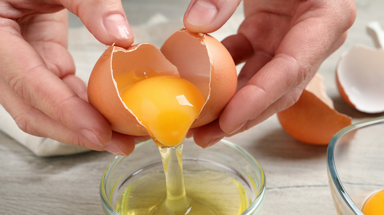 person separating egg yolk