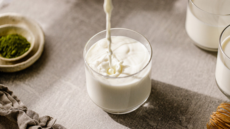 fresh milk being poured into glass