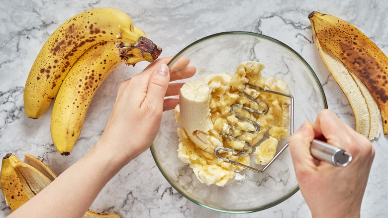 Person mashing fresh bananas